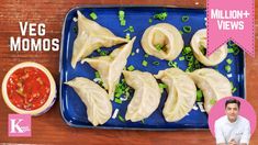 a blue plate topped with dumplings next to a bowl of ketchup and sauce