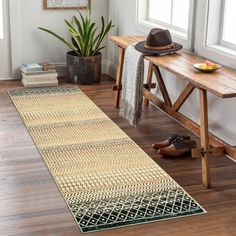 a room with a wooden bench and rug on the floor