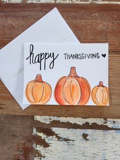 a card with three pumpkins on it and the words happy thanksgiving written in black ink