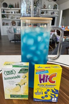 blue liquid in a blender with lemonade next to it and two cartons of ice