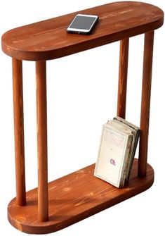 a wooden table with a cell phone on it and a magazine rack holding two books