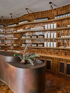 an empty counter in a store with lots of bottles on the wall and shelves behind it