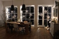 a dining room filled with lots of windows covered in snowflakes and christmas lights