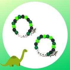 two bracelets with green and black beads, one has a small dinosaur on it