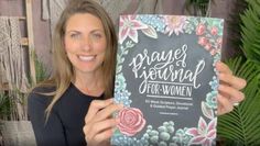 a woman holding up a book that says prayer journal for women with flowers on it