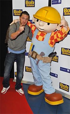 a man standing next to a giant cartoon character