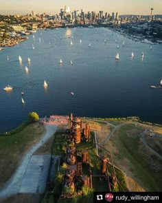 an aerial view of sailboats in the water near a large city with tall buildings