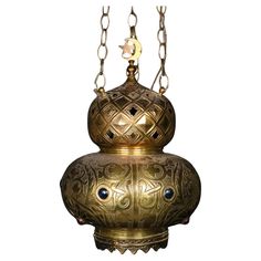 an ornate brass hanging light fixture with blue eyes