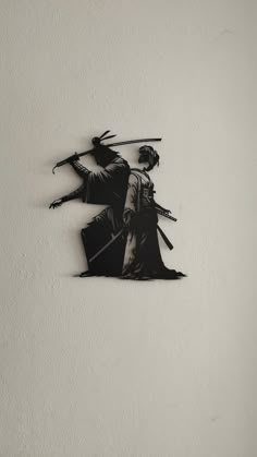 a black and white photo of two people with swords in their hands on a wall