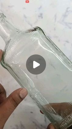 someone is holding a glass bottle in their hand and opening it up to show the inside