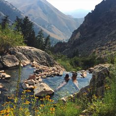 two people in a hot spring surrounded by mountains