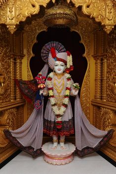 a statue of a hindu god with flowers in his hair