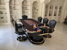 a black table with lots of dice on it in a room filled with shelves and chairs