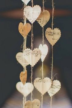 some paper hearts hanging from strings with music notes on them and string attached to the strings