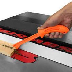 a person is using an orange handled tool to cut through the edge of a box