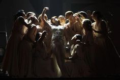 a group of women standing on top of a stage with their arms in the air