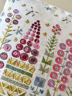 a close up of a piece of embroidery on a table cloth with flowers and leaves