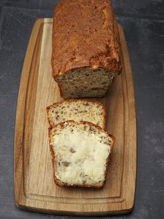 a loaf of bread sitting on top of a cutting board next to a slice of cheese