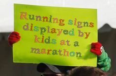 a person holding up a sign that says running signs displayed by kids at a marathon