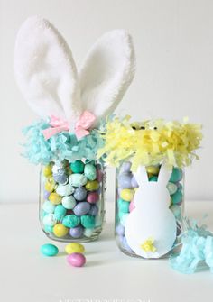 two mason jars filled with candy and decorated easter bunnies, one has an egg in it