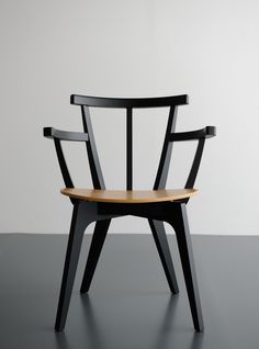 a black and wooden chair sitting on top of a gray floor