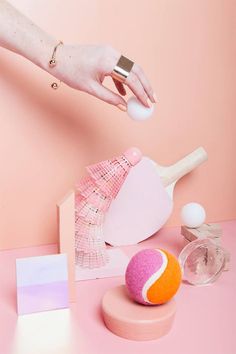 a person's hand reaching for an object on top of a pink countertop