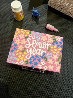 a pink notebook with the words semor year written on it next to other items