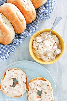 two bagels and a bowl of cream cheese on a table