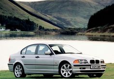 a silver car parked in front of a lake