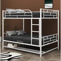 a white bunk bed sitting on top of a wooden floor next to a brown wall