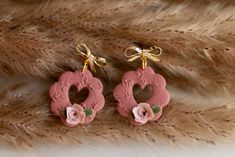 two pairs of pink earrings with flowers on them