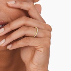 a close up of a person with a ring on their finger and one hand near her face