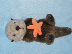 a stuffed animal with an orange star on it's chest laying down in the middle of a blue blanket