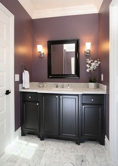 a bathroom with two sinks and a large mirror above the sink, along with dark wood cabinetry