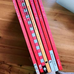 four red pencils sitting on top of a wooden table