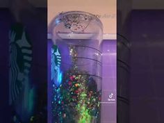 a starbucks cup filled with confetti and sprinkles in a display case