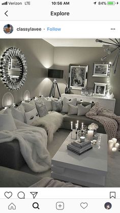 a living room filled with lots of white furniture and candles on top of the coffee table