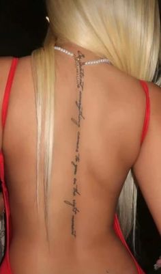 the back of a woman's body with tattoos on it and words written in cursive writing