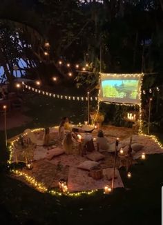 people are sitting in the middle of a circle with lights on it and there is a projection screen behind them