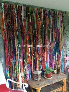 there is a room with many colorful ribbons hanging on the wall and two chairs in front of it