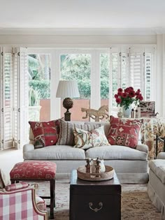 a living room filled with furniture and a fire place in front of a large window