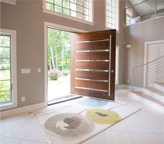 an open door in a large room with white tile flooring and wooden paneling