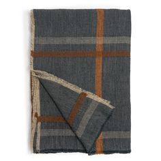 a blue and brown plaid blanket folded on top of a white table with an orange stripe