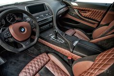 the interior of a bmw car with brown leather and black stitching on the floor