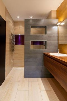 a bathroom with a sink, mirror and tiled walls