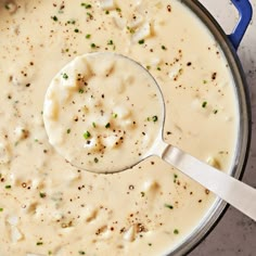 a ladle full of soup is being held by a spoon