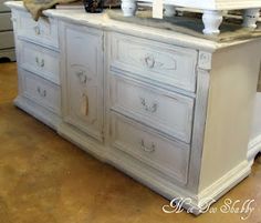 an old dresser is painted white and has two birds on top