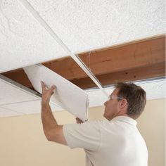 a man is working on the ceiling in his home