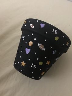 a black cup with stars and numbers on it sitting on a white sheet covered bed