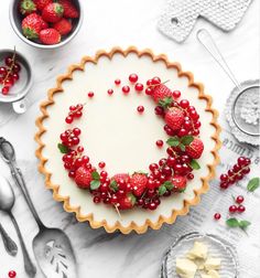 there is a pie with strawberries on it and other desserts around the cake